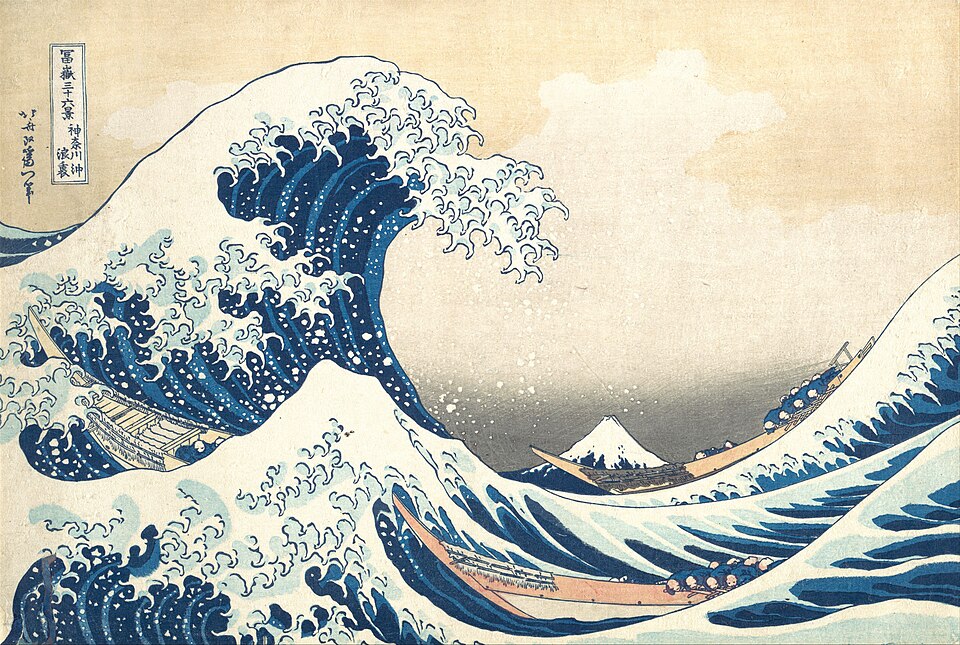 A large curling wave rises over boats, with Mount Fuji in the distance.