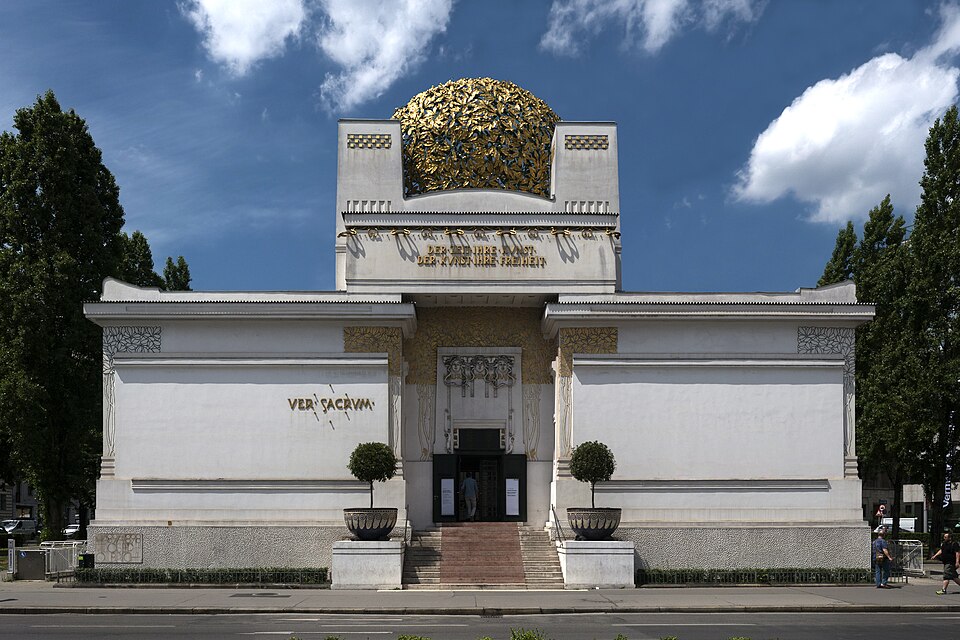 White Vienna Secession building with a gold lattice dome, seen from the front.