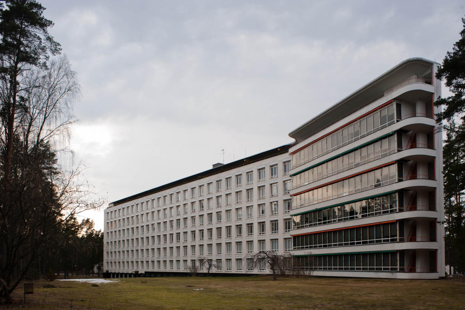 Long white Paimio Sanatorium building seen beneath an overcast sky.